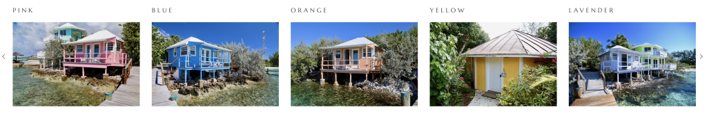 A row of five colorful waterfront cottages, labeled pink, blue, orange, yellow, and lavender, sits serenely near the Yacht Club at Staniel Cay. The vibrant homes are complemented by clear skies and lush greenery.